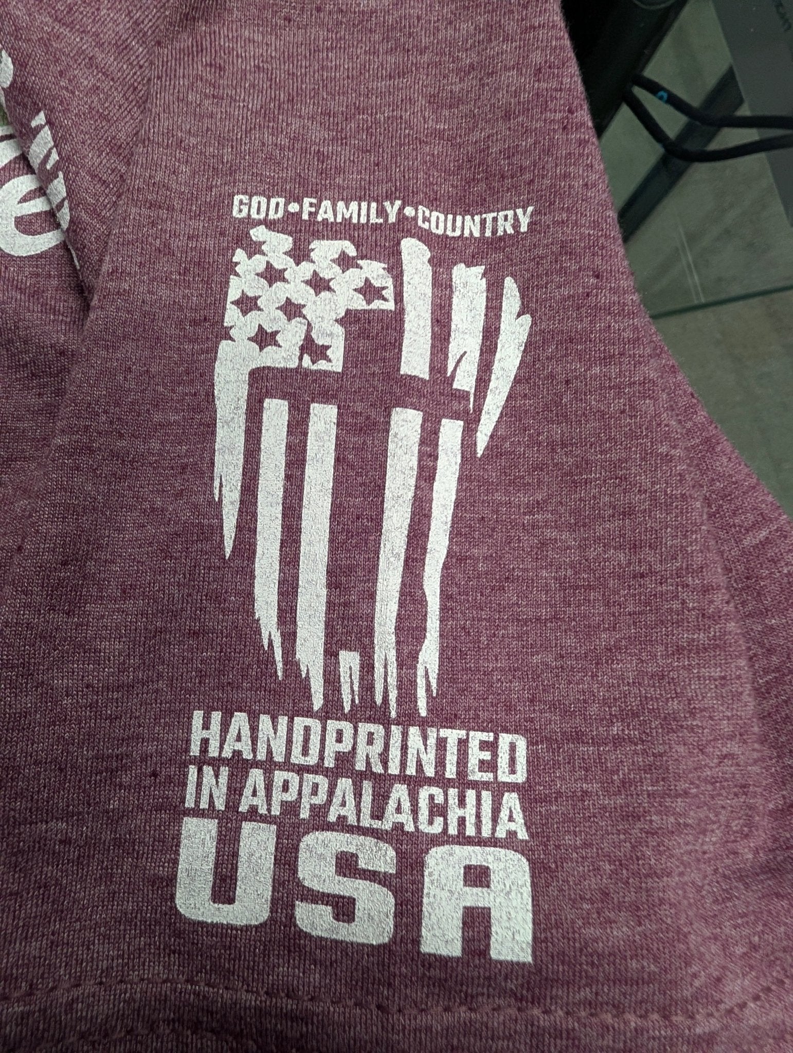 The "22 A Day" Premium Veteran Awareness Tee - Meridian EDC | Laserworks - Maroon shirt with white graphic and text on a blurred background
