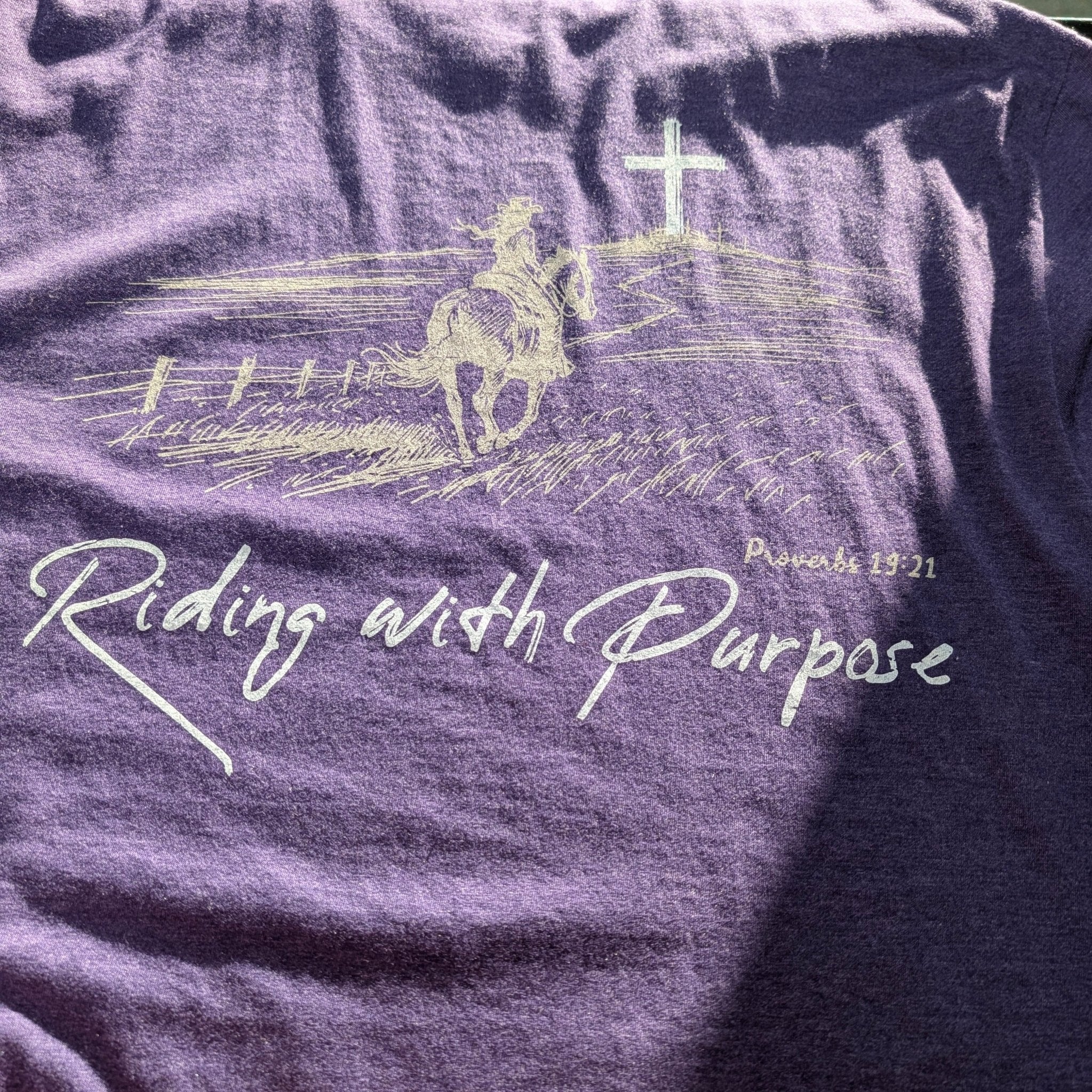 The "Day 41" Premium Graphic Tee - Meridian EDC | Laserworks - Purple t-shirt with a graphic of a horse and rider and the text 'Riding with Purpose'.