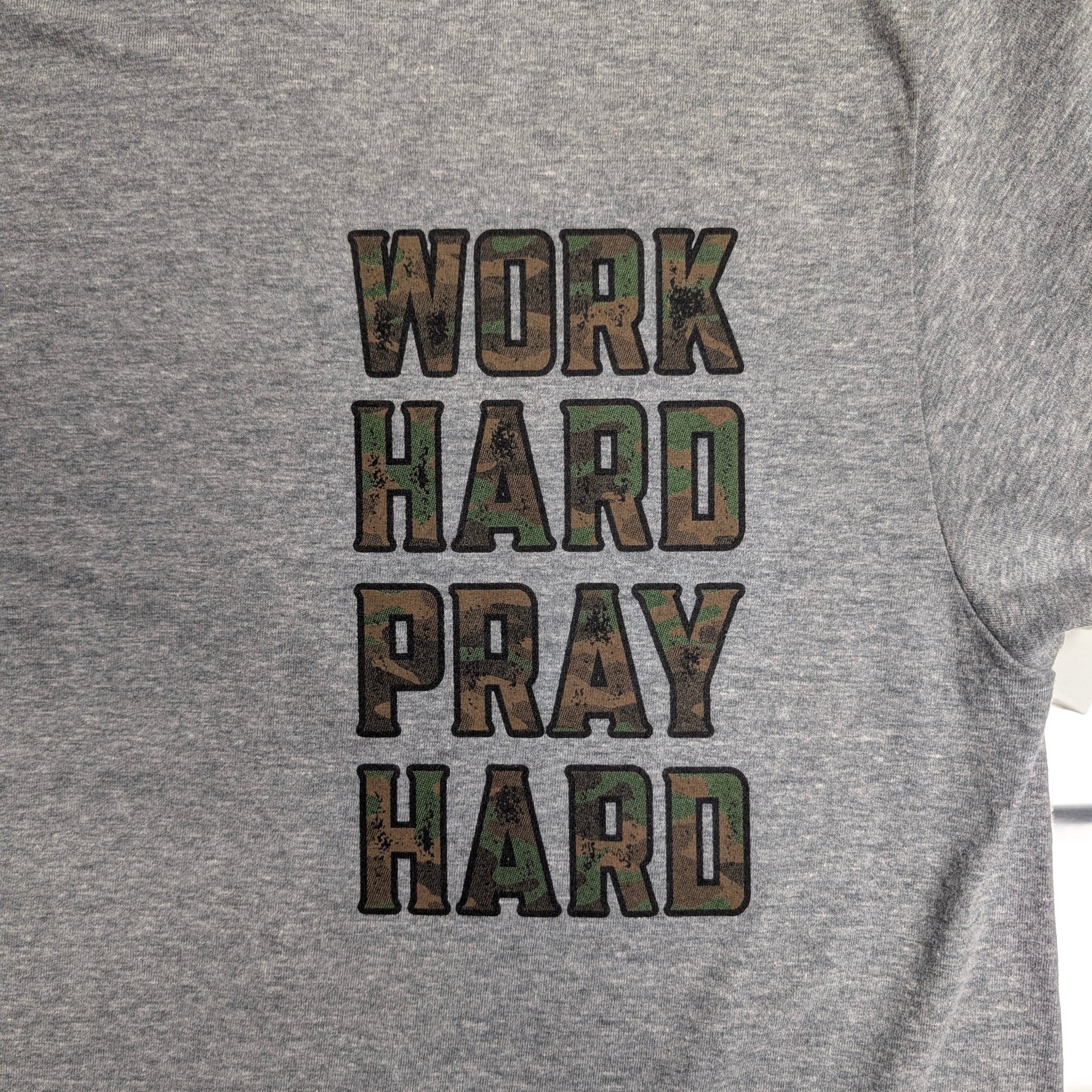 The "Faith & Fortitude" Premium Graphic Tee - Work Hard, Pray Hard - Meridian EDC | Laserworks - Gray sweatshirt with 'Work Hard Pray Hard' text in camouflage print.