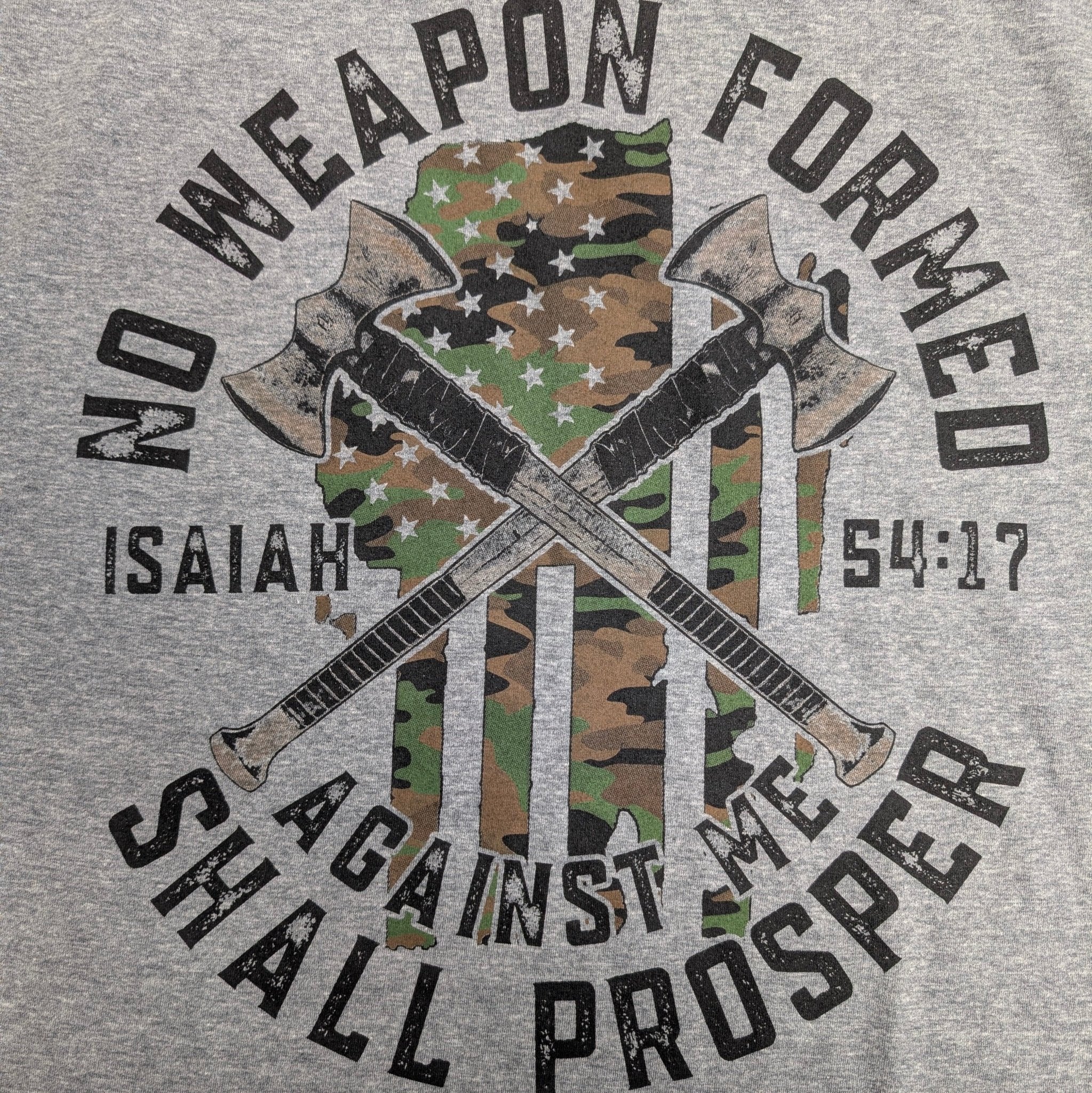 The "Faith & Fortitude" Premium Graphic Tee - Work Hard, Pray Hard - Meridian EDC | Laserworks - Gray t-shirt with crossed axes, camouflage pattern, and Bible verse 'No weapon formed against me shall prosper' on a gray background.