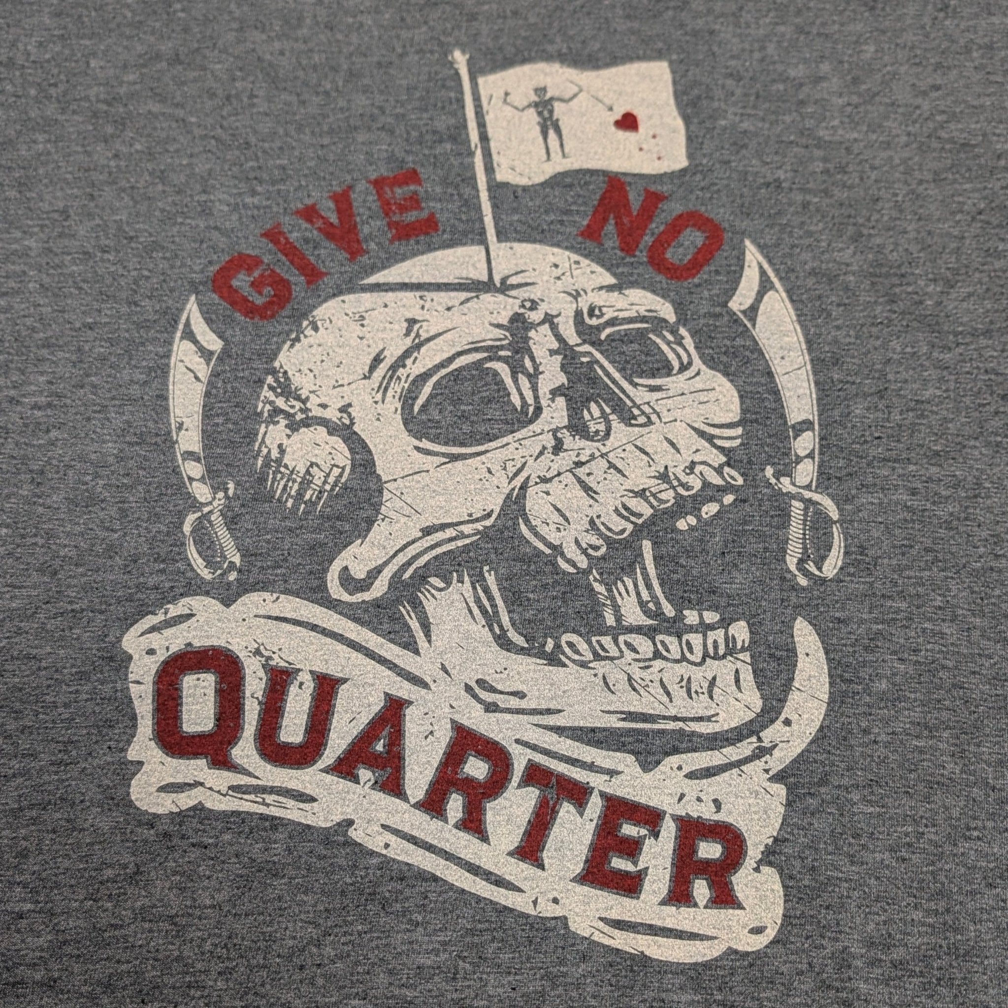 The "Killdozer: Give No Quarter" Premium Graphic Tee - Meridian EDC | Laserworks - Gray t-shirt with a skull graphic and 'Give No Quarter' text on a table.